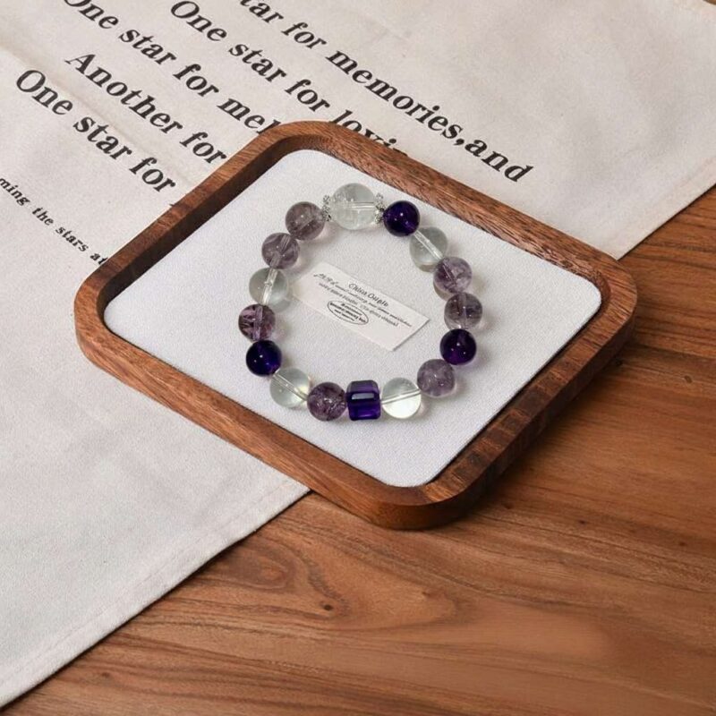 A close-up detail shot of the green rutilated quartz crystal bead on the Bing Fire bracelet.