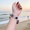 A woman wearing the Bing Fire crystal energy bracelet, showing how it looks on the wrist.