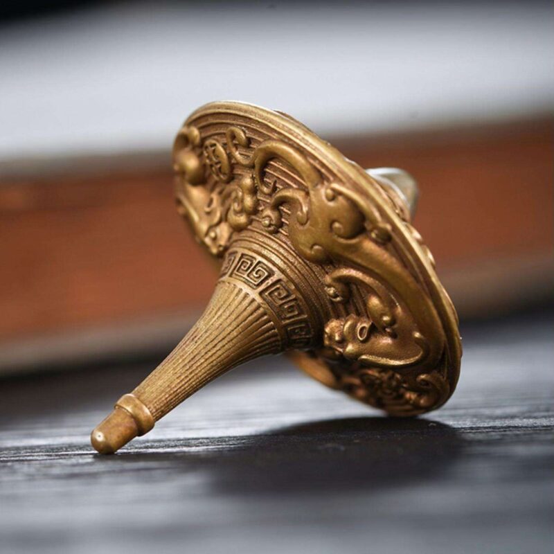 The Celestial Dragon brass fidget spinner in mid-spin, showing a hypnotic blur of the dragon carvings and its perfect balance.
