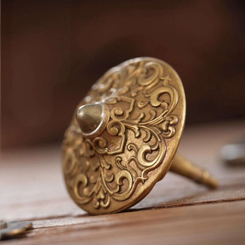 A top-down macro shot of the brass fidget spinner, highlighting the detailed relief carving of the two intertwined celestial dragons.