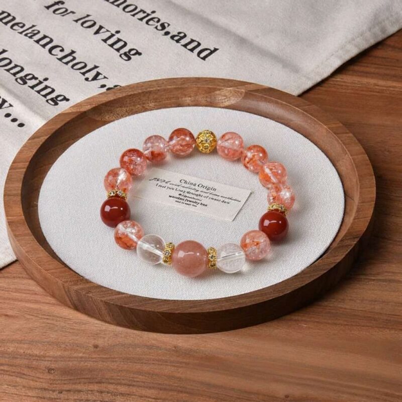 A close-up detail shot of the red lodolite quartz crystal bead on the Aries Zodiac.