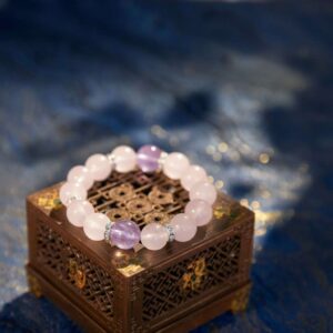 A Pisces Zodiac crystal bracelet with Rose quartz beads. Alt Text 2: A close-up detail shot of the Rose quartz crystal bead on the Piscess Zod