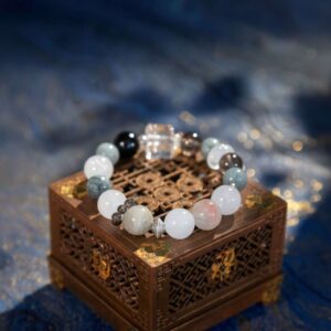 A Chinese Dog Zodiac crystal bracelet with green rutilated and phantom quartz beads.