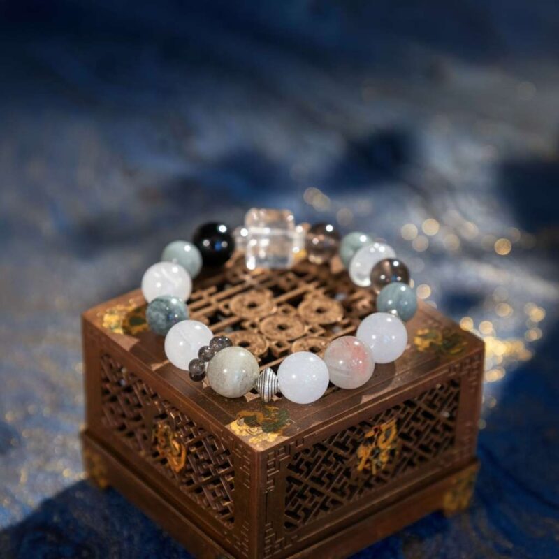 A Chinese Dog Zodiac crystal bracelet with green rutilated and phantom quartz beads.