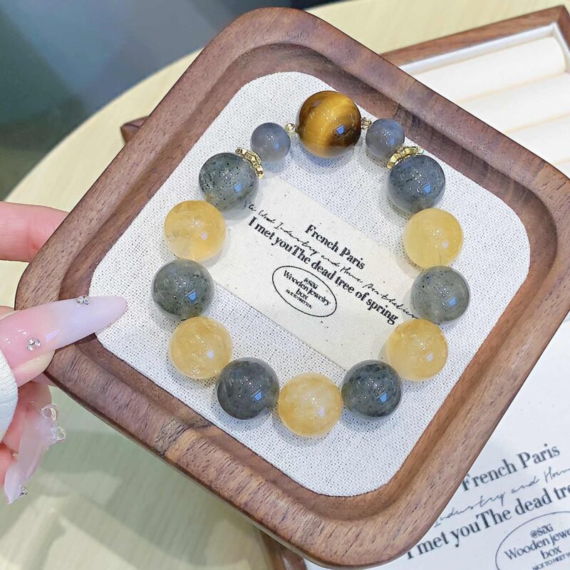 A close-up detail shot of the green rutilated quartz crystal bead on the Chinese Horse Zodiac.