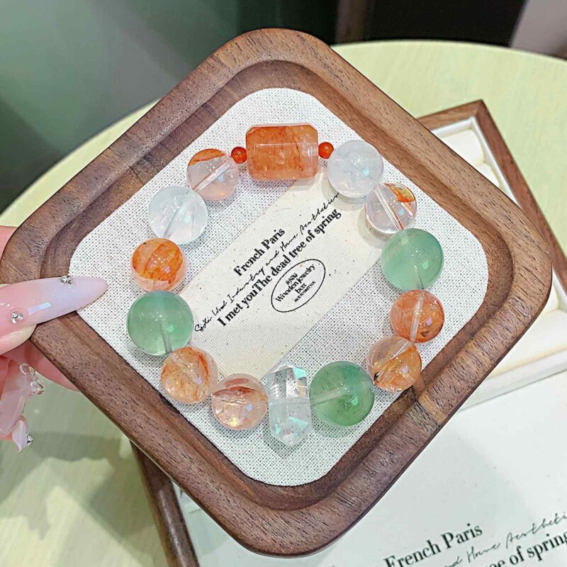 A close-up detail shot of the green rutilated quartz crystal bead on the Chinese Ox Zodiac.