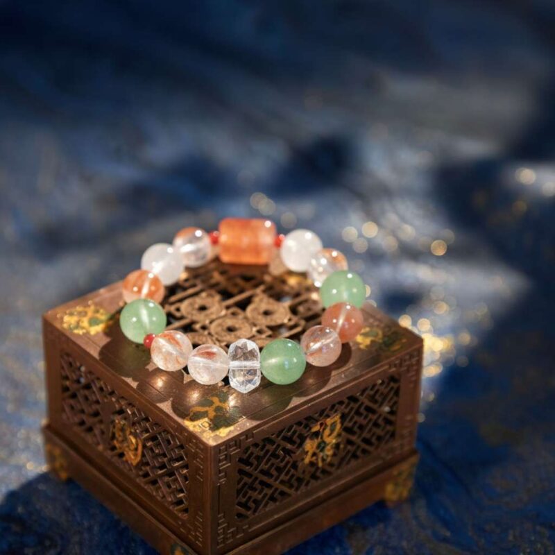 A Chinese Ox Zodiac crystal bracelet with green rutilated and phantom quartz beads.