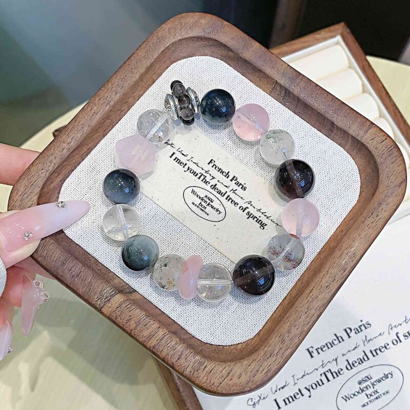 A close-up detail shot of the green rutilated quartz crystal bead on the Chinese Pig Zodiac.