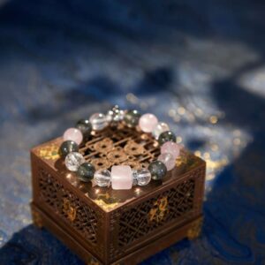 A Chinese Pig Zodiac crystal bracelet with green rutilated and phantom quartz beads.