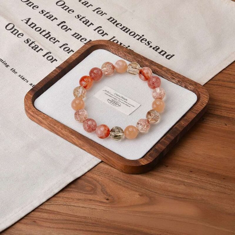 A close-up detail shot of the green rutilated quartz crystal bead on the Ding Fire bracelet.