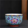 The imperial detailed Interlocking Lotus enameled handmade ceramic teacup, showcasing intricate pink and white lotus flowers.