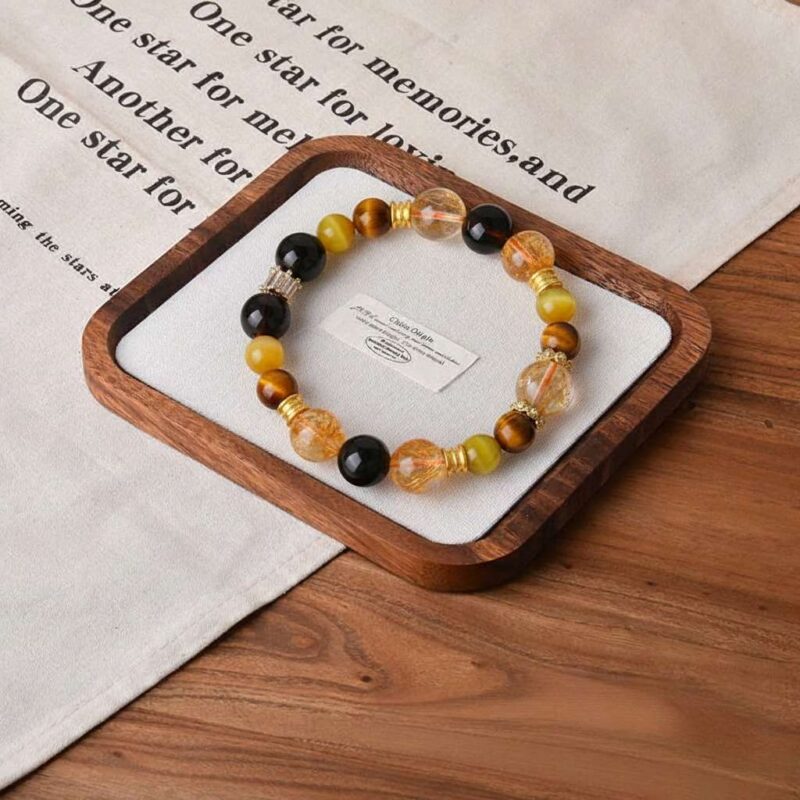 A close-up detail shot of the green rutilated quartz crystal bead on the Geng Metal bracelet.