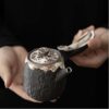 The Lotus Rhyme Kyusu, a Japanese-style side-handle handmade ceramic teapot with intricate silver and black glaze details.