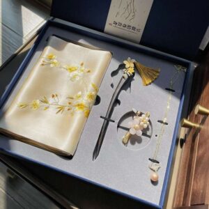 An elegant, open Handmade Suzhou Embroidery Silk Gift Box displaying its contents: a hand-embroidered silk scarf, an ebony hairpin, a pearl necklace, and an enamel brooch.