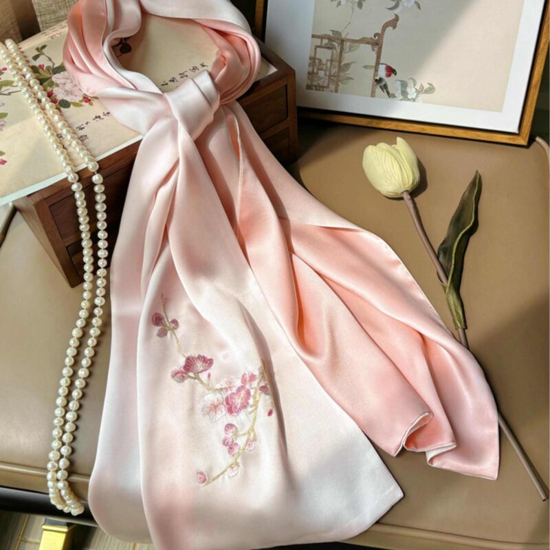 An elegant, open pink Handmade Suzhou Embroidery Silk Gift Box displaying its contents: a hand-embroidered silk scarf, an ebony hairpin, a pearl necklace, and an enamel brooch.