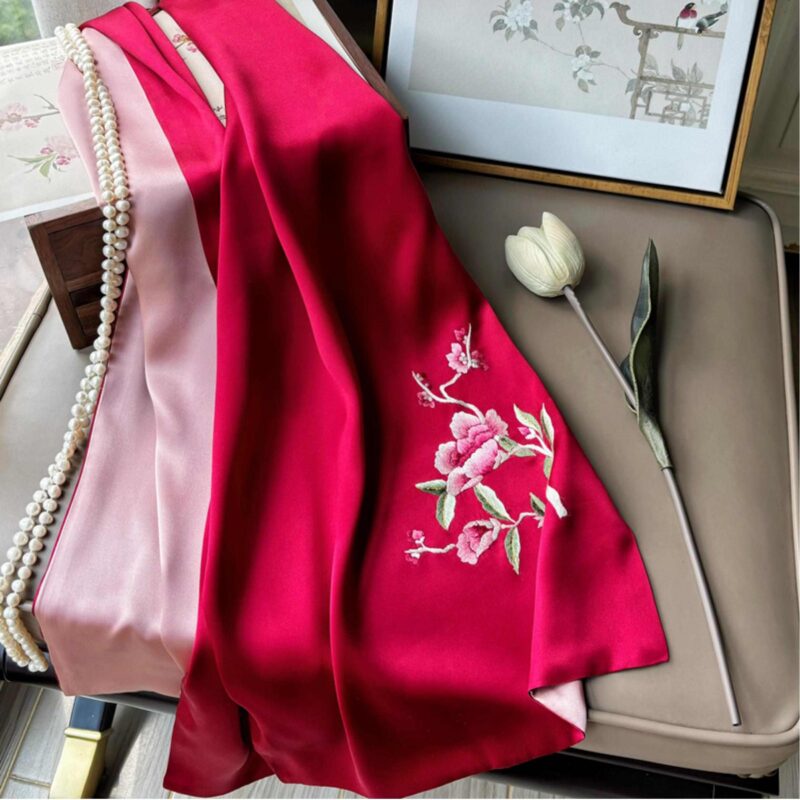 An elegant, open red Handmade Suzhou Embroidery Silk Gift Box displaying its contents: a hand-embroidered silk scarf, an ebony hairpin, a pearl necklace, and an enamel brooch.