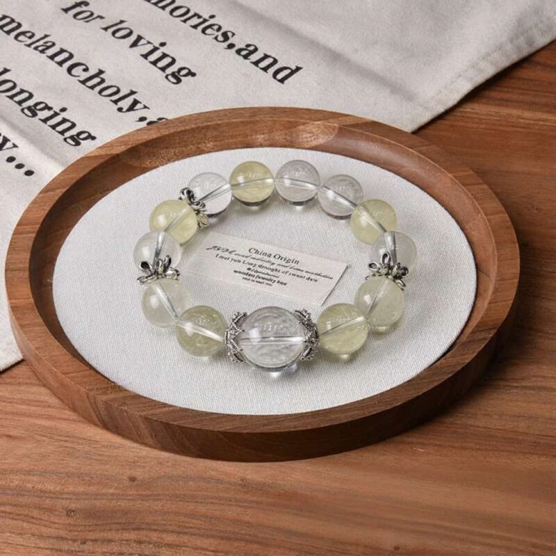 A close-up detail shot of the green rutilated quartz crystal bead on the Ji Earth bracelet.