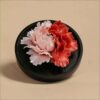 The handmade flower ceramic diffuser shown in a stunning deep red and pink peony color variation.