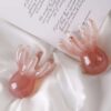 A beautiful pink marbled resin octopushead massage tool on the desk.