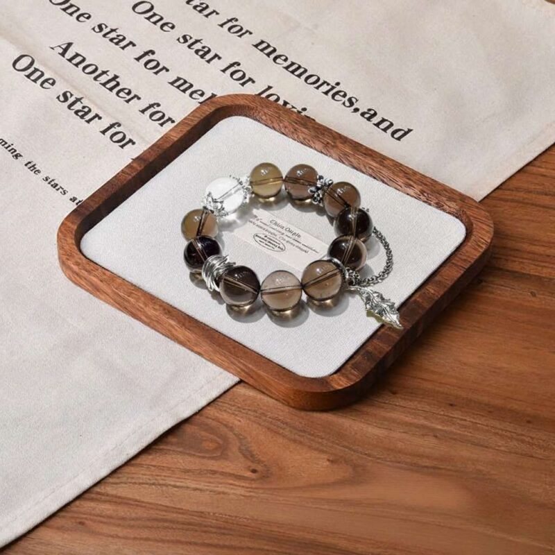 A close-up detail shot of the green rutilated quartz crystal bead on the Wu Earthd bracelet.