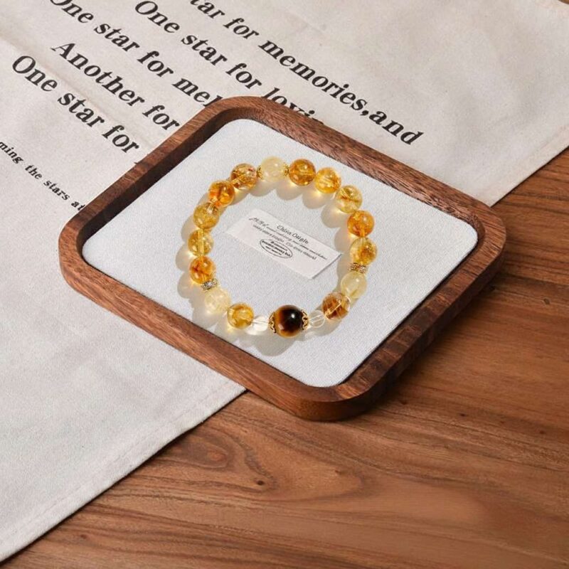 A close-up detail shot of the green rutilated quartz crystal bead on the Xin Metal bracelet.