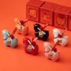 Lucky 2026 year of the horse ceramic ornament in red and assorted colors, featuring a cute rounded design and a wealth scroll on the back, displayed on an orange background.