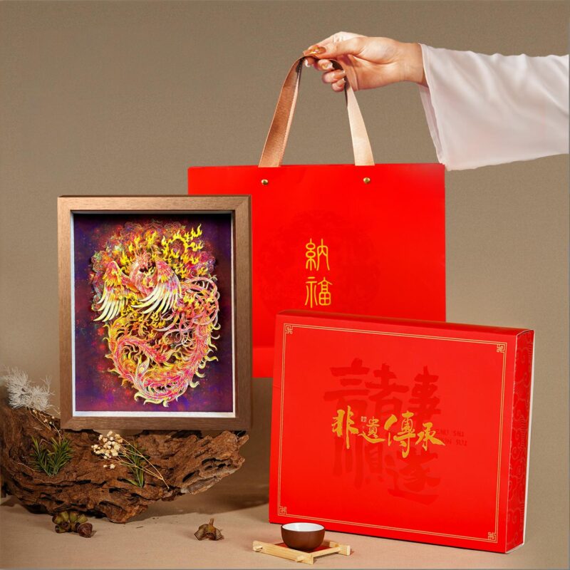 Close up of the 3D Chinese Paper Cutting Fenghuang, detailing the multi-layered feathers and the 'King of Birds' motif in vibrant gold and red.