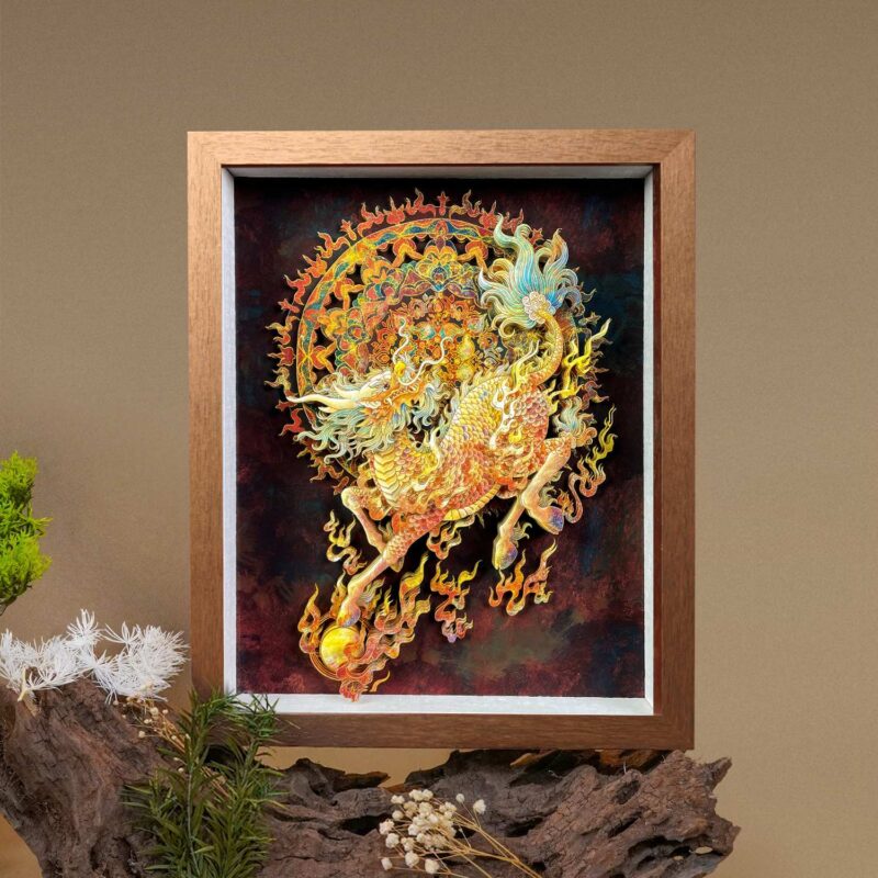 Framed 3D Chinese Paper Cutting Qilin art piece displayed on driftwood, showcasing the intricate golden scales and fiery design of the mythical beast