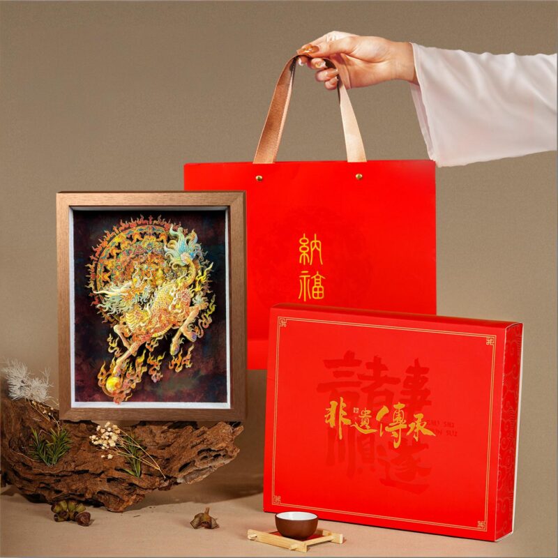 Red gift box with gold calligraphy next to the 3D Chinese Paper Cutting Qilin shadow box, perfect for Lunar New Year or corporate gifting.