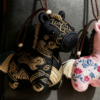 Collection of Handmade Brocade Guardian Horse Embroidery Amulet charms in pink, black, and other colors, hanging together to show the variety of Lunar New Year gifts.