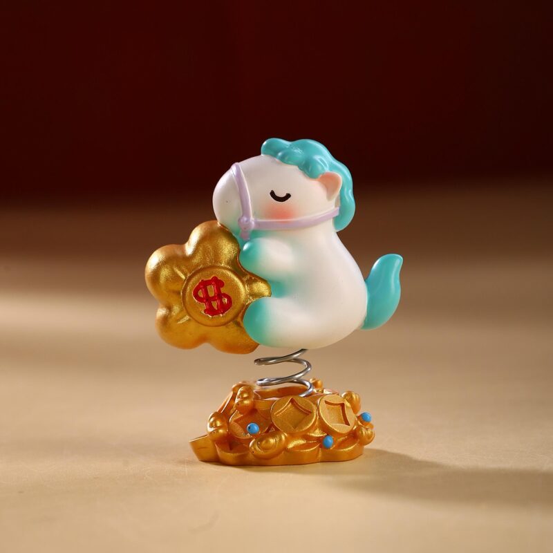 Close up of the Instant Wealth Year of the Horse Creative Spring Ornament with pink hair holding a gold ingot, mounted on a coin base with a spring.