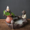 "Close up of the fisherman figure on the Backflow Incense Burner Fishing Alone sitting by a misty smoke pond, creating a meditative Zen vibe.