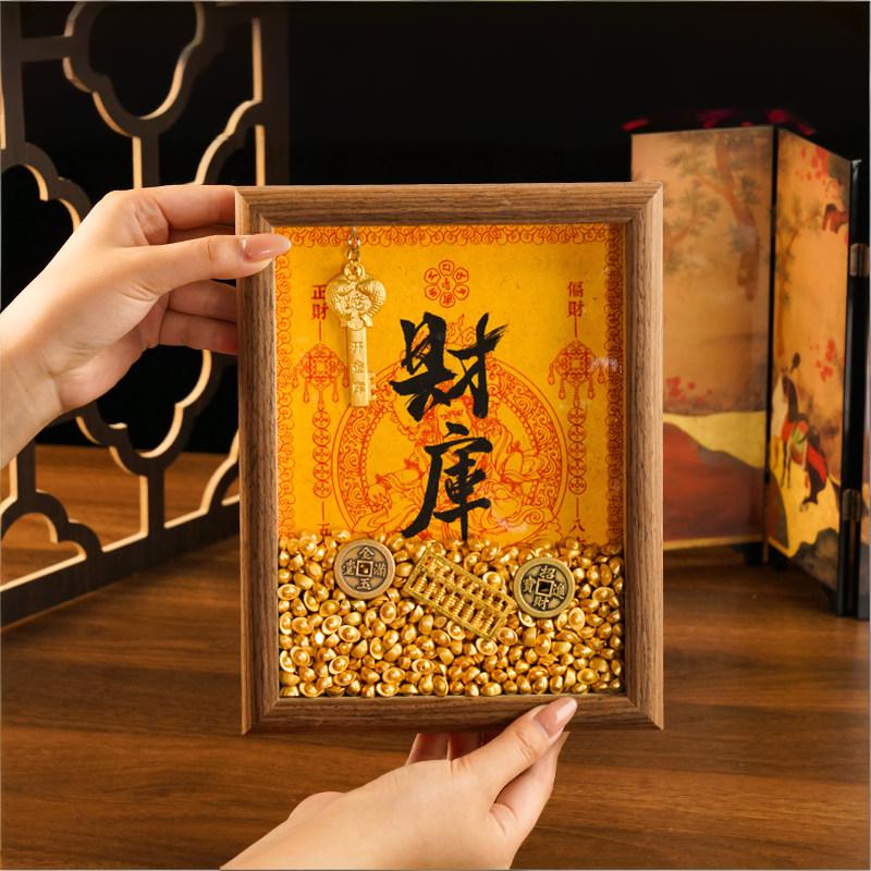 Hands holding a Walnut-colored Feng Shui Wealth Opening Frame, showing the depth of the shadow box and the abundance of gold yuanbao inside.