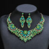 Emerald green Luxury Crystal Glass Party Jewelry Set featuring a marquise-cut floral statement necklace and matching dangle earrings on a black display bust.