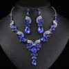 Sapphire blue Luxury Crystal Glass Party Jewelry Set featuring a V-shaped teardrop rhinestone necklace and matching dangle earrings on a black display bust.